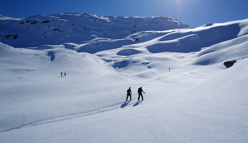 Cross-country skiers traversing a snowy landscape, promoting winter outdoor activities for health and fitness.