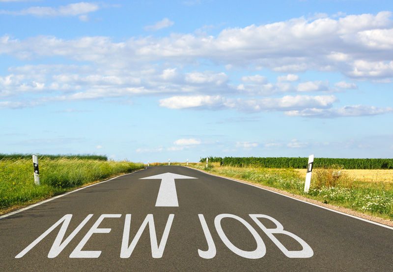 Road with "NEW JOB" painted on it, symbolizing career opportunities and job hunting.