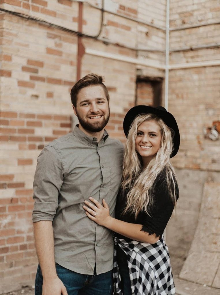 Young couple smiling together in an urban setting, showcasing a friendly and approachable demeanor, reflecting the personal connection emphasized by Optimized Health Plans' commitment to client relationships.